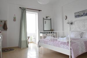 a bedroom with a white bed and a mirror at Romantic Apartment in Adelianos Kampos