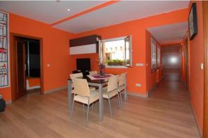 comedor con paredes de color naranja, mesa y sillas en Apartamento C/Real,9, en Toledo