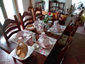 una mesa de comedor con un juego de mesa con desayuno en La Vie En Rose, en Buia