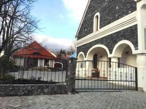 un bâtiment avec une porte en face d'une maison dans l'établissement BASALTINA Panzió, à Balatonederics