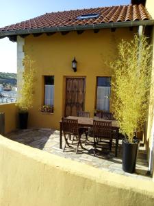 un patio con mesa y sillas frente a una casa en En busca del viento del norte en Santillana del Mar