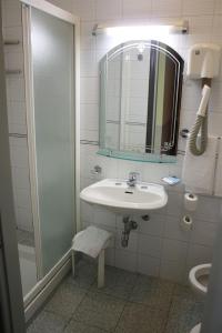 a bathroom with a sink and a shower and a mirror at Hotel Mazzini in Milan