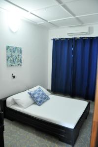 1 dormitorio con 1 cama con cortina azul en Villa Ekabo, en Cotonou