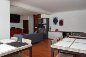 a kitchen and living room with tables and a couch at Casa70 in Setúbal