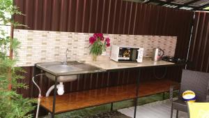 a counter with a sink and flowers on a patio at Guest House Dacha in Karolino-Buhaz