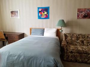 a bedroom with a bed and a couch and a lamp at Melsask Motel in Melville