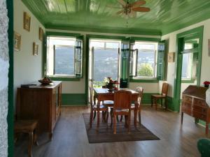 comedor con paredes verdes, mesa y sillas en Quinta do Sol - Soutelo, en Chã