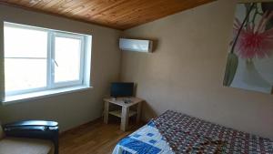 a small bedroom with a bed and a window at Guest House Dacha in Karolino-Buhaz