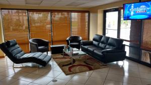 una sala de espera con sillas de cuero y TV en Rodeway Inn Davenport-Champions Gate, en Davenport