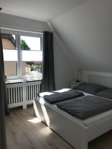 ein Schlafzimmer mit einem großen Bett und einem Fenster in der Unterkunft Ferienapartment Kischa in Scharbeutz