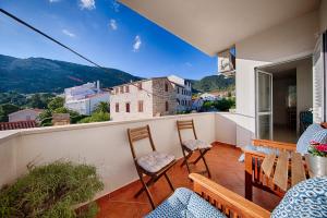 a balcony with chairs and a view of a city at Apartments Marinkovic Komiza in Komiža