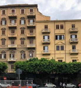 ein großes Gebäude mit Balkonen und davor geparkt in der Unterkunft Al Massimo 36 in Palermo