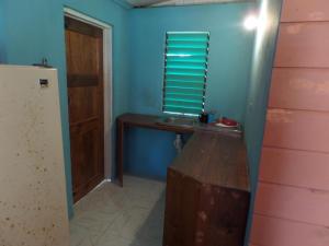a room with a wooden table and a window at Jah B's Cottages on Beach Road-Negril in Negril