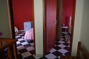 a room with a door and a checkerboard floor at Estalagem Toledo in Cunha