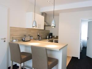 a kitchen with a counter with two chairs in it at Nordsee Domizil Schobüll in Husum