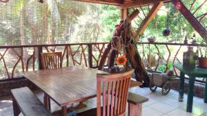 a porch with a wooden table and chairs on a balcony at Haere Mai I Te Fare in Teavaro