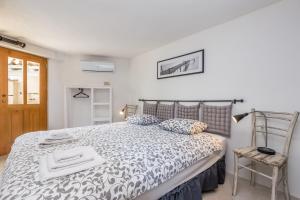 a bedroom with a bed with a black and white comforter at Holiday Home Jela in Dobrinj +32 photos