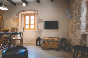 a living room with a table and a tv on the wall at Holiday Home Jela in Dobrinj