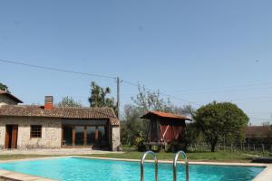 a swimming pool in front of a house and a building at Organic Farm Bouçós in Vila Verde