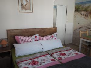 Schlafzimmer mit einem Bett mit rosa und weißen Kissen in der Unterkunft Kaisers Eck Ferienwohnung in Ahlbeck