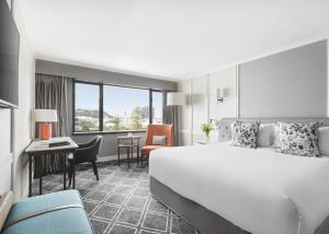 a hotel room with a bed and a desk at Cordis, Auckland by Langham Hospitality Group in Auckland