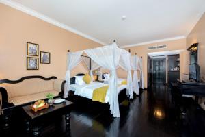 a bedroom with two beds and a canopy bed at Pacific Hotel & Spa in Siem Reap