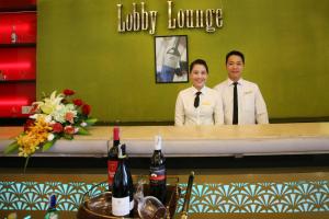 two people standing behind a counter in a restaurant at Park View Hotel in Hue