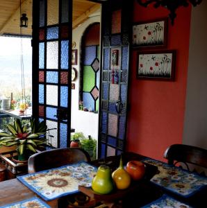 a dining room with a table and stained glass windows at El Pedregal Sopó in Sopó