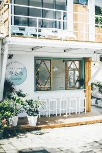 een restaurant met witte stoelen op een gebouw bij Yellow's Kenting B&B in Nanwan