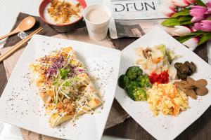 dos platos blancos de comida en una mesa en Zhen 13 Villa Motel, en Yongkang