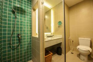 a bathroom with a shower and a sink and a toilet at Garden Sentral Hotel in Kuala Belait