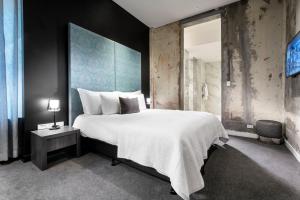 a bedroom with a large bed and a large window at The Melbourne Hotel in Perth