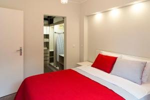 a bedroom with a red and white bed and a mirror at Apartamento Ideal 3 in Lisbon