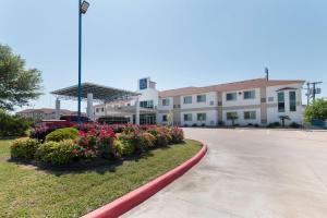 ein Gebäude mit Blumen vor einer Straße in der Unterkunft Motel 6-Hillsboro, TX in Hillsboro