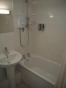 a bathroom with a sink and a tub and a shower at The Lodge in Barnby Dun