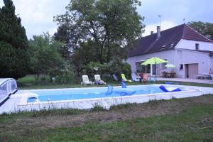 a swimming pool in the yard of a house at le gîte de Marinette in Villers-Robert