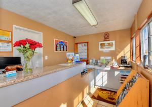 a kitchen with a counter with a vase of red flowers at Bayside Inn in Monterey