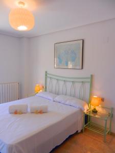 a bedroom with a large white bed with two lamps at Oceanográfico Apartments in Valencia