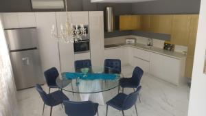 une salle à manger avec une table en verre et des chaises bleues dans l'établissement Marry's house, à Karianí