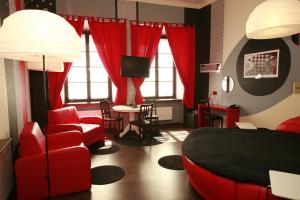 ein Schlafzimmer mit einem roten Bett, einem Stuhl und einem Tisch in der Unterkunft Castle Inn in Warschau