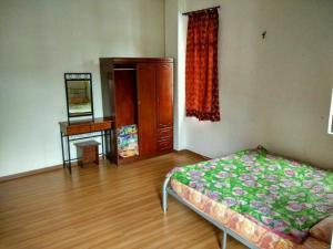 1 dormitorio con 1 cama, vestidor y escritorio en Bzout rents, en Cameron Highlands