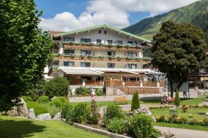 un hotel con jardín frente a un edificio en Haller's Posthotel, en Riezlern