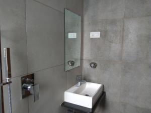 a bathroom with a white sink and a mirror at Manasi Pride in Satara