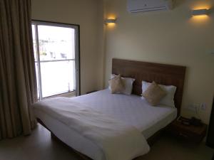 a bedroom with a large bed with a window at Manasi Pride in Satara