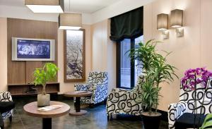 une salle d'attente avec des chaises, des tables et des plantes dans l'établissement Hostal Ballesta, à Madrid