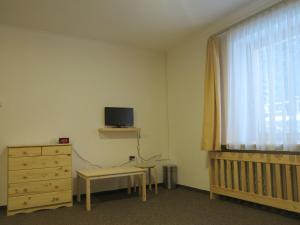 a bedroom with a crib and a dresser and a window at Penzion Zornicka in Donovaly