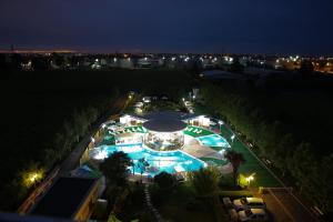 una vista panoramica su una grande piscina di notte di Mari Vila Hotel a Bucarest