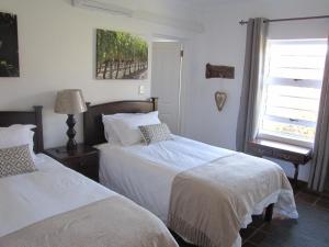 1 dormitorio con 2 camas y ventana en Induku, en Stellenbosch