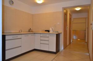 a kitchen with white cabinets and a tile floor at Hostel Gdańsk Sun and Sea in Gdańsk