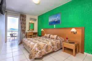 a hotel room with a bed and a green wall at Avra Hotel in Methana